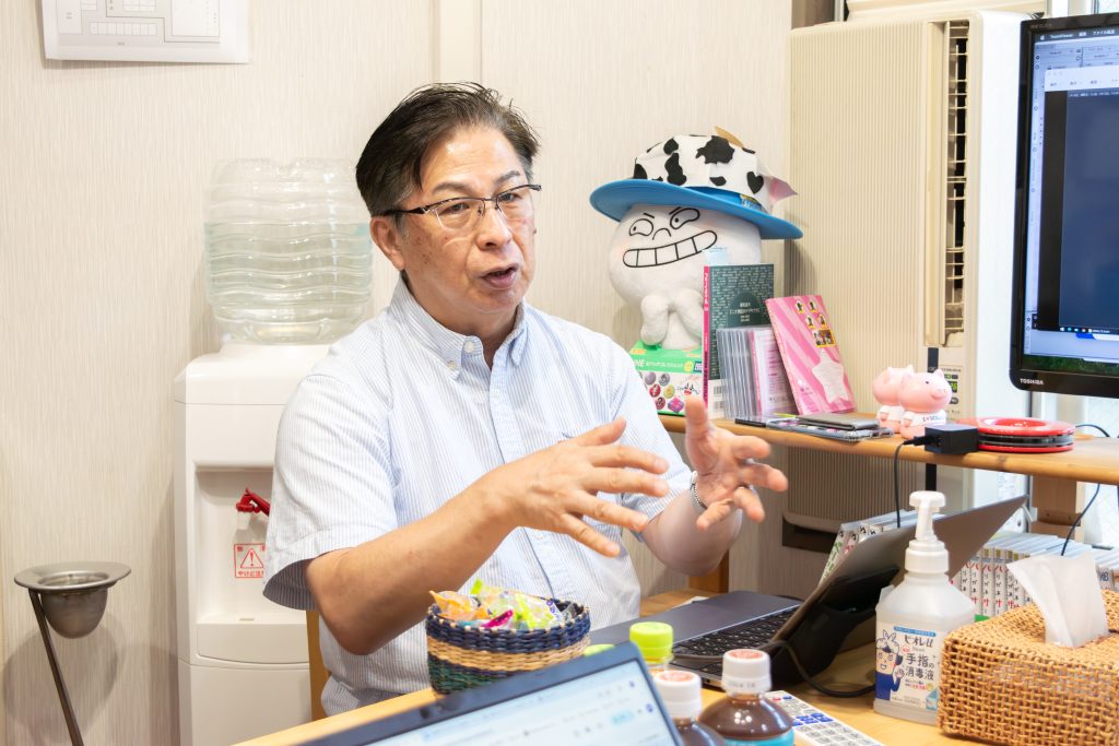 株式会社岡安プロモーション 代表取締役 岡安隆氏と、現場を支える編集スタッフのインタビュー風景。